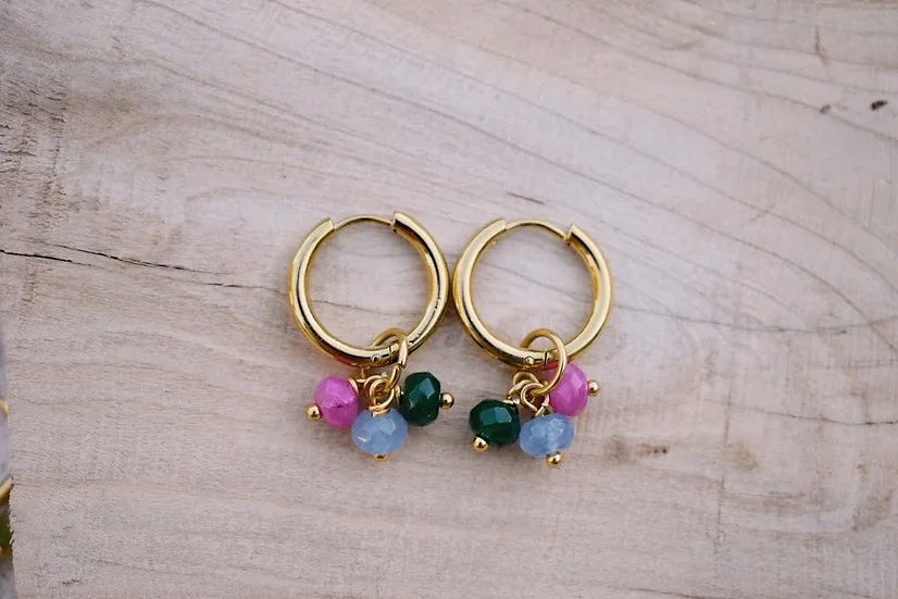 Argolas Treviso de aço com jade facetado, com jade verde e rosa, sobre madeira