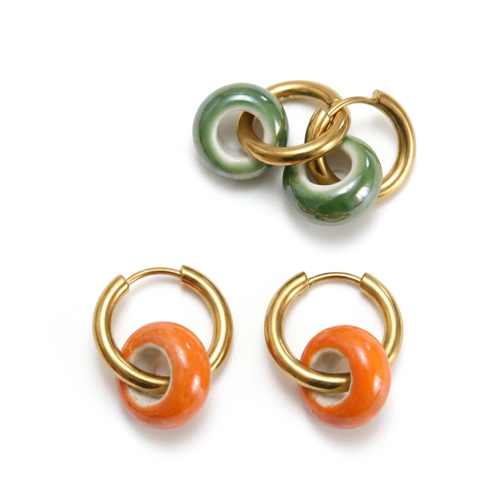 Brincos de argolas de aço com aros de cerâmica, com aros verde e laranja, em fundo branco