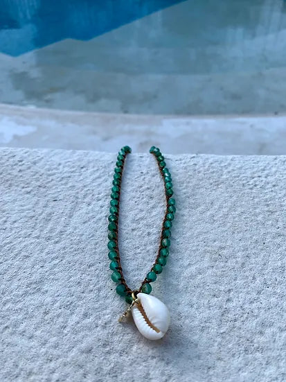 Colar Bacio di Mare de ágatas com concha, verde, sobre pedra junto à piscina