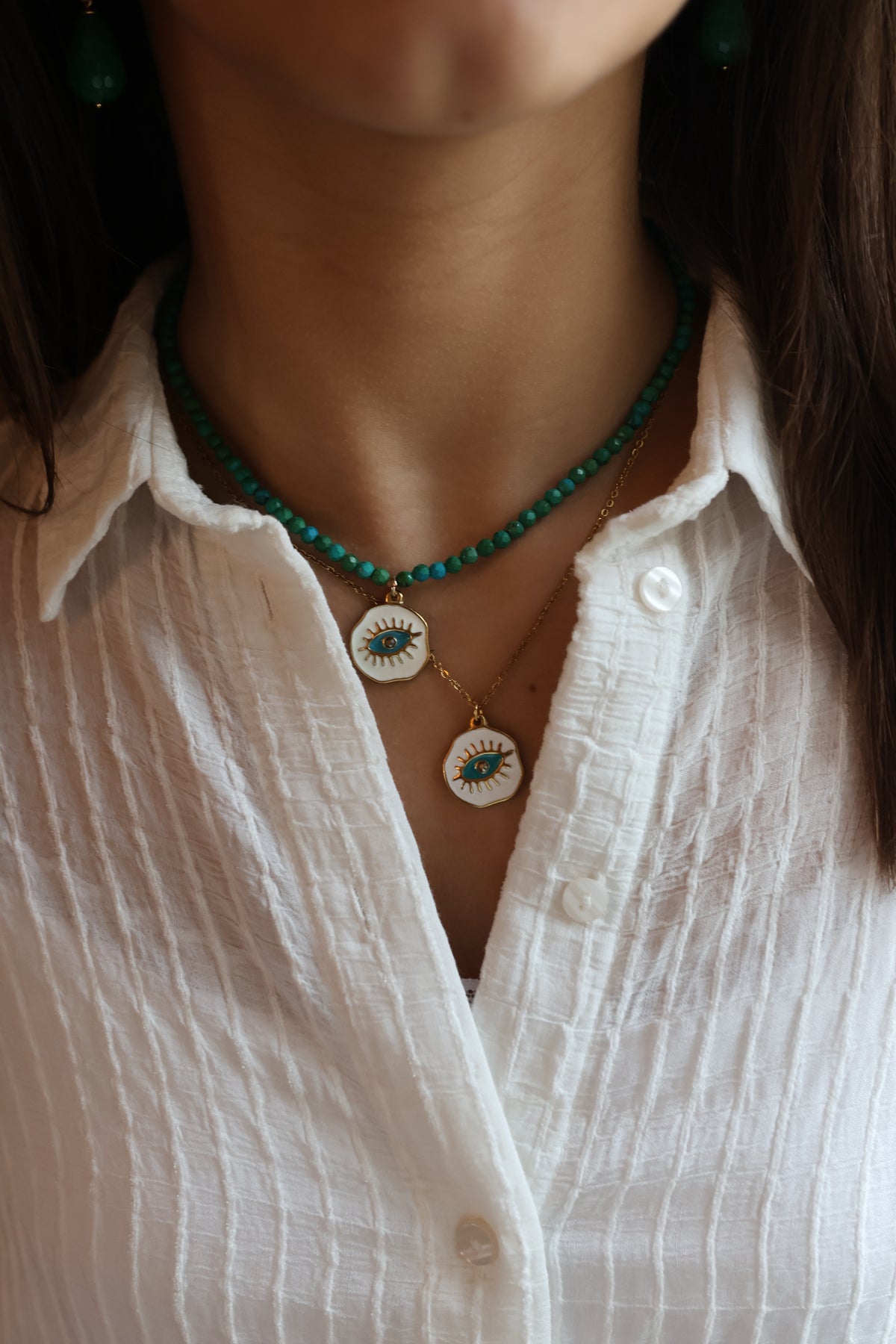 Colar Blueyes com medalha de aço esmaltada, usado ao pescoço com camisa branca