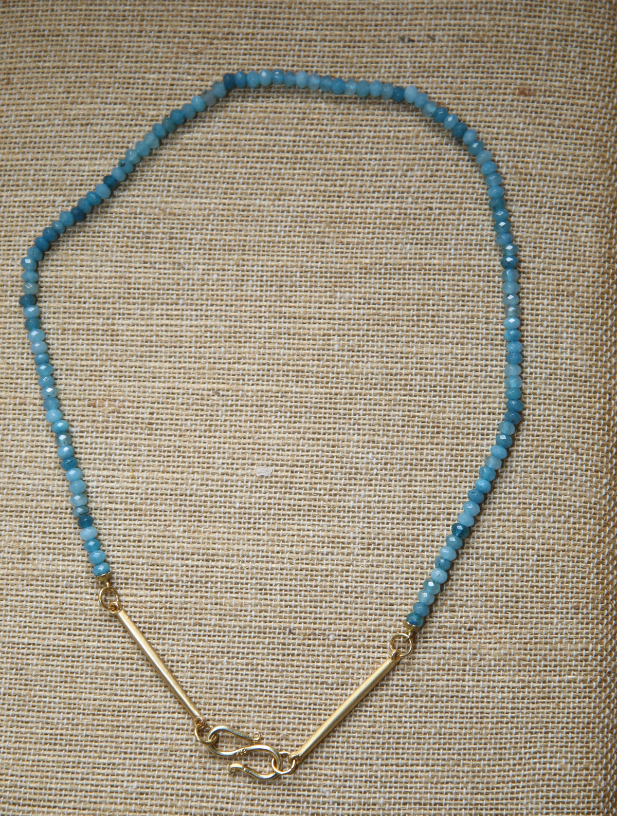 Colar Bridão de jade facetado, azul, sobre tecido de linho