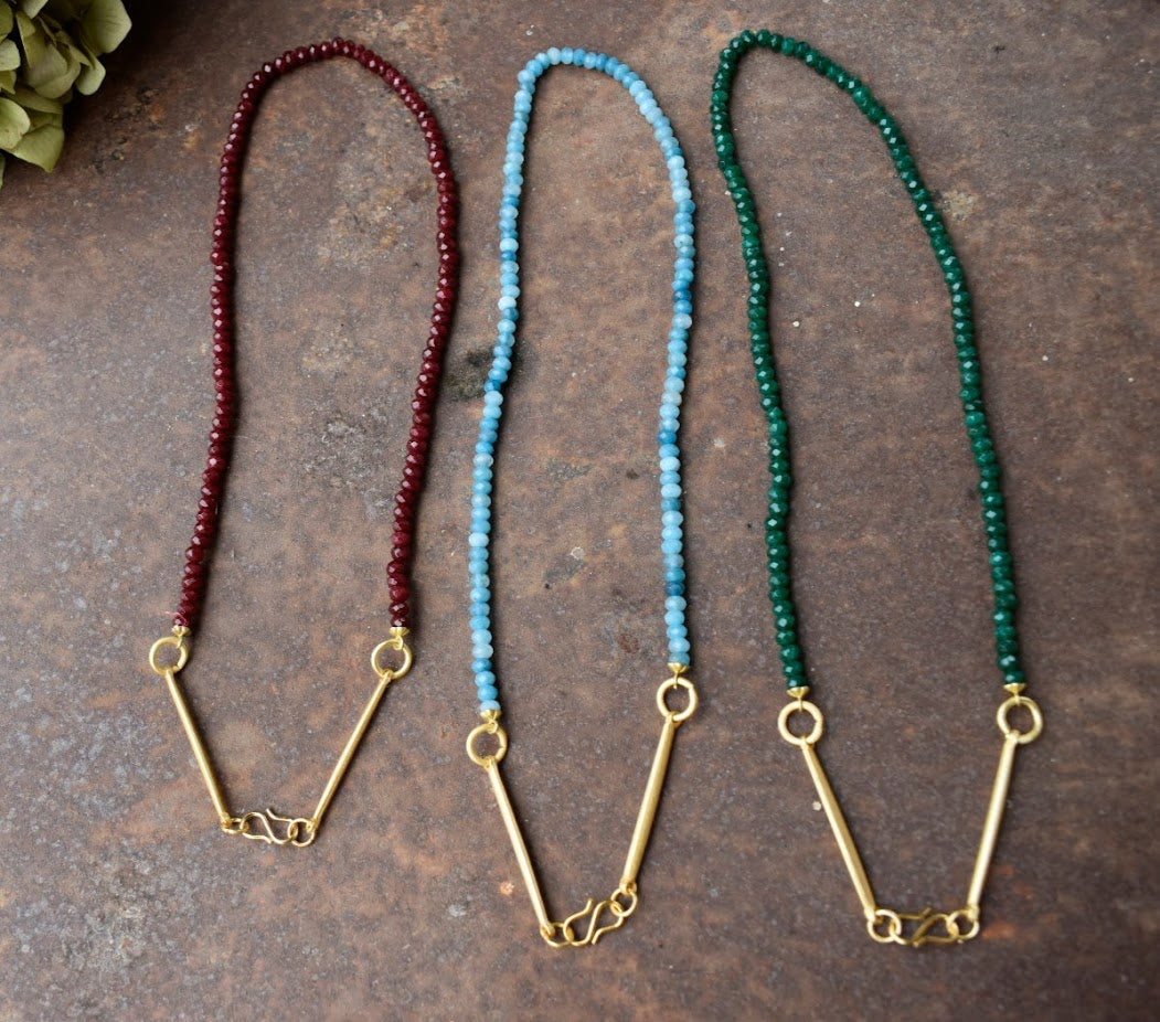 Colar Bridão de jade facetado, três cores lado a lado, sobre pedra escura