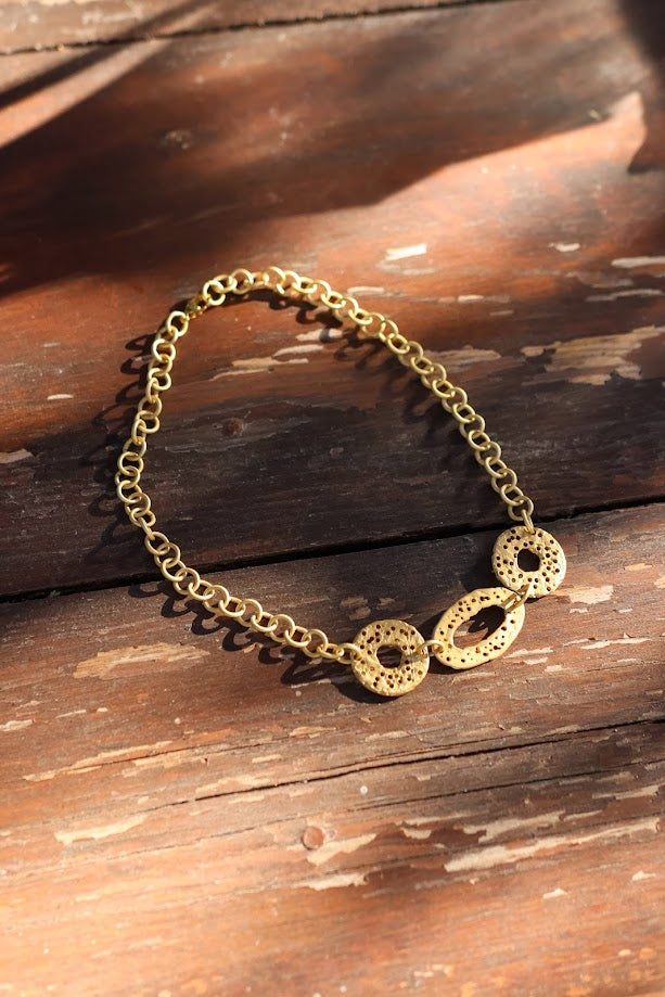 Colar Choker de corrente dourada, sobre madeira