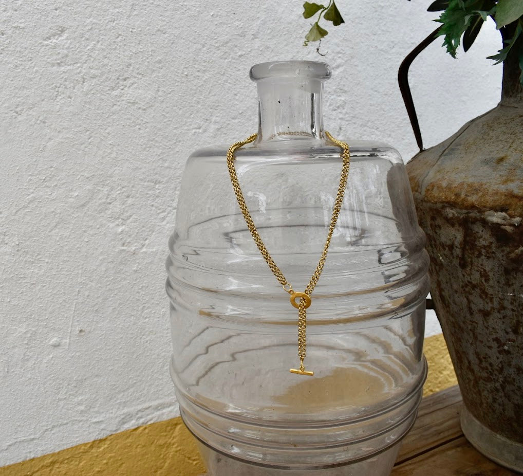 Colar Dakota de corrente de aço, pendurado numa garrafa de vidro
