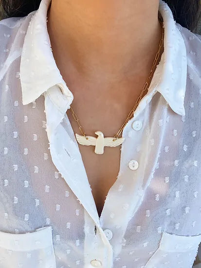 Colar Espírito Santo de aço com pendente acrílico, usado ao pescoço com blusa branca