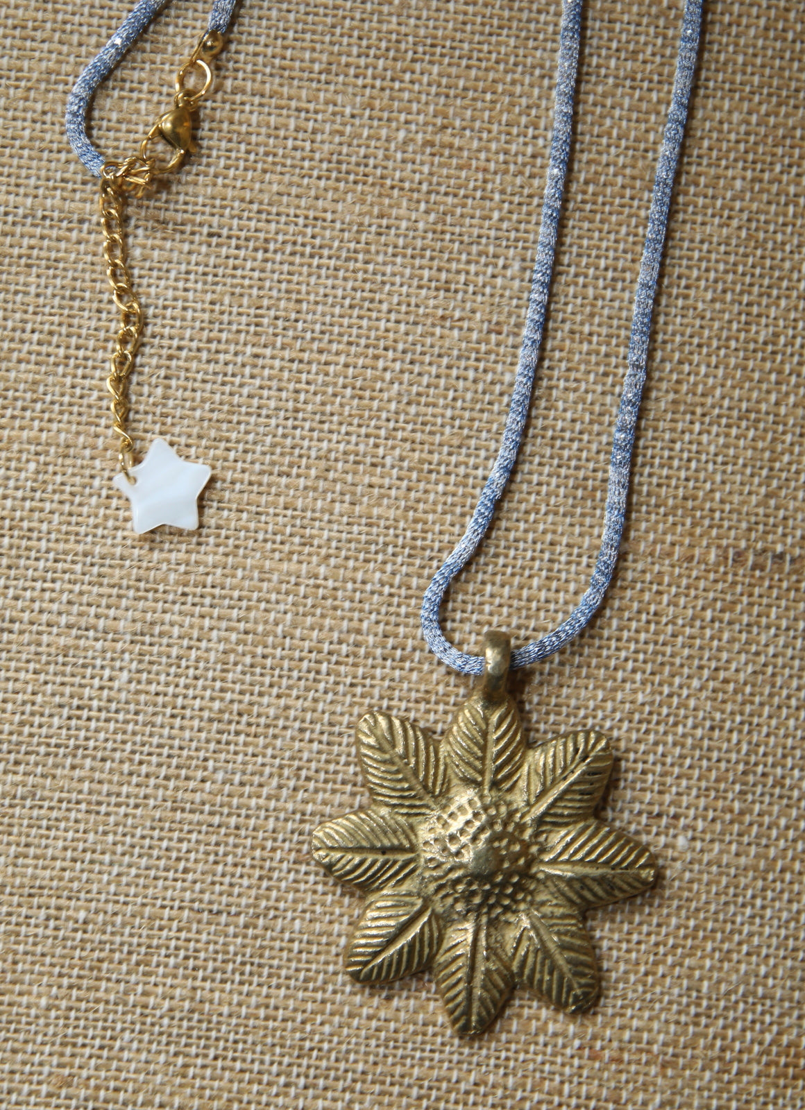 Colar com flor de bronze, sobre tecido de linho