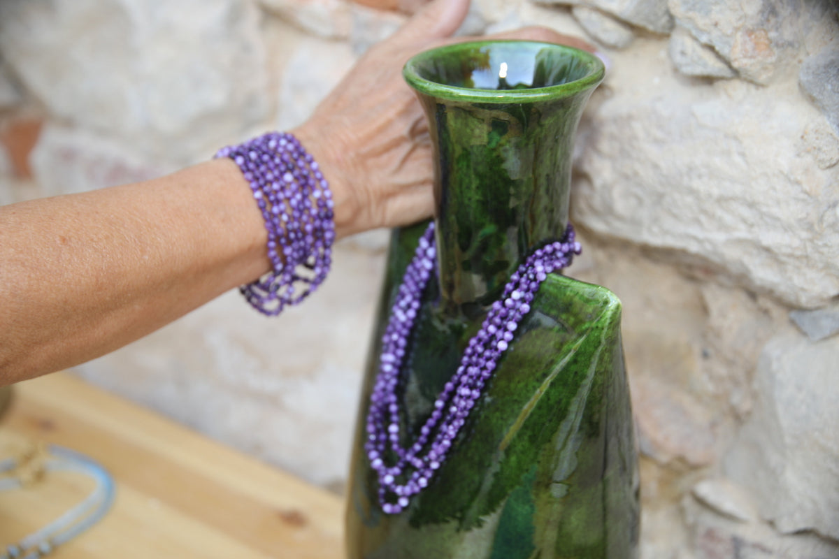 Colar Infinity de ágatas em fio de seda, roxo, usado no pulso e numa jarra de vidro