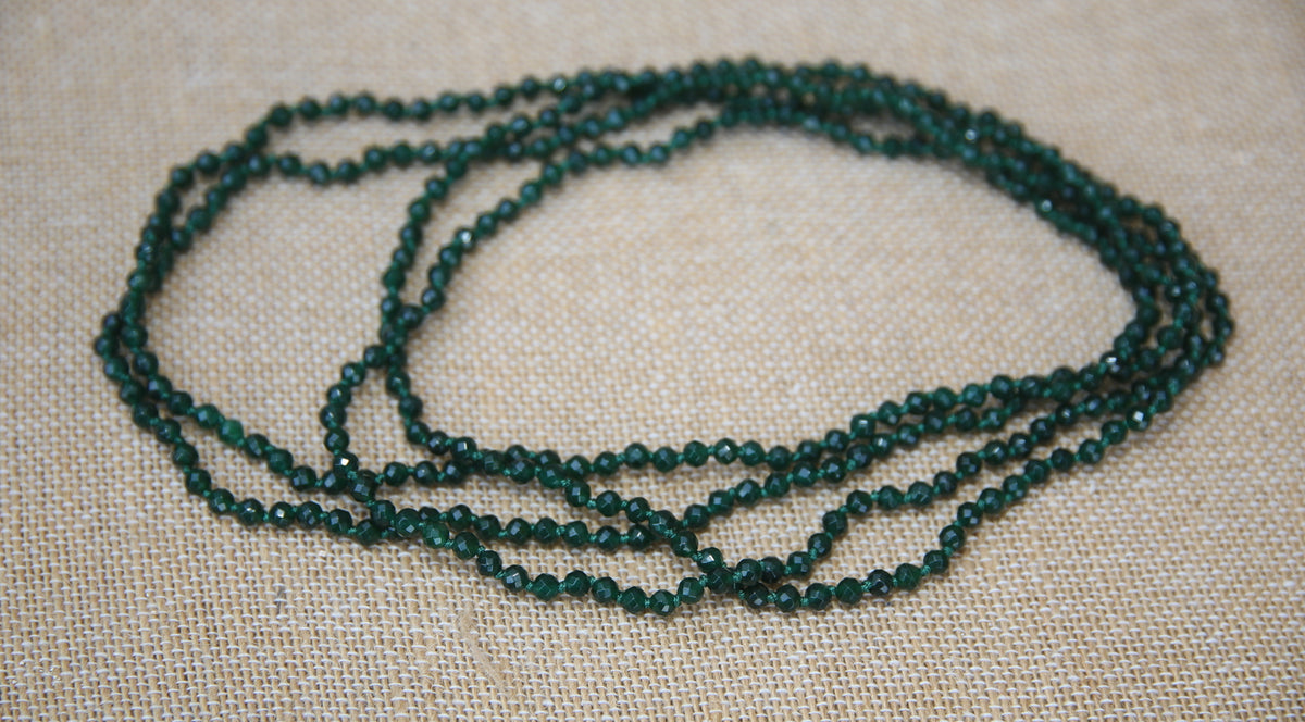 Colar Infinity de ágatas em fio de seda, verde-escuro, sobre tecido de linho
