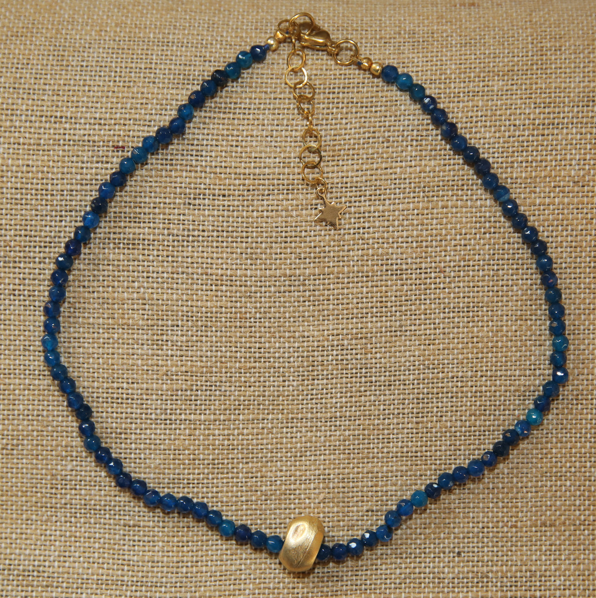 Colar Luísa de ágatas e aço dourado, azul-escuro, sobre tecido de linho