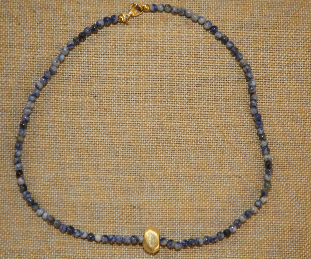 Colar Luísa de ágatas e aço dourado, azul, sobre tecido de linho