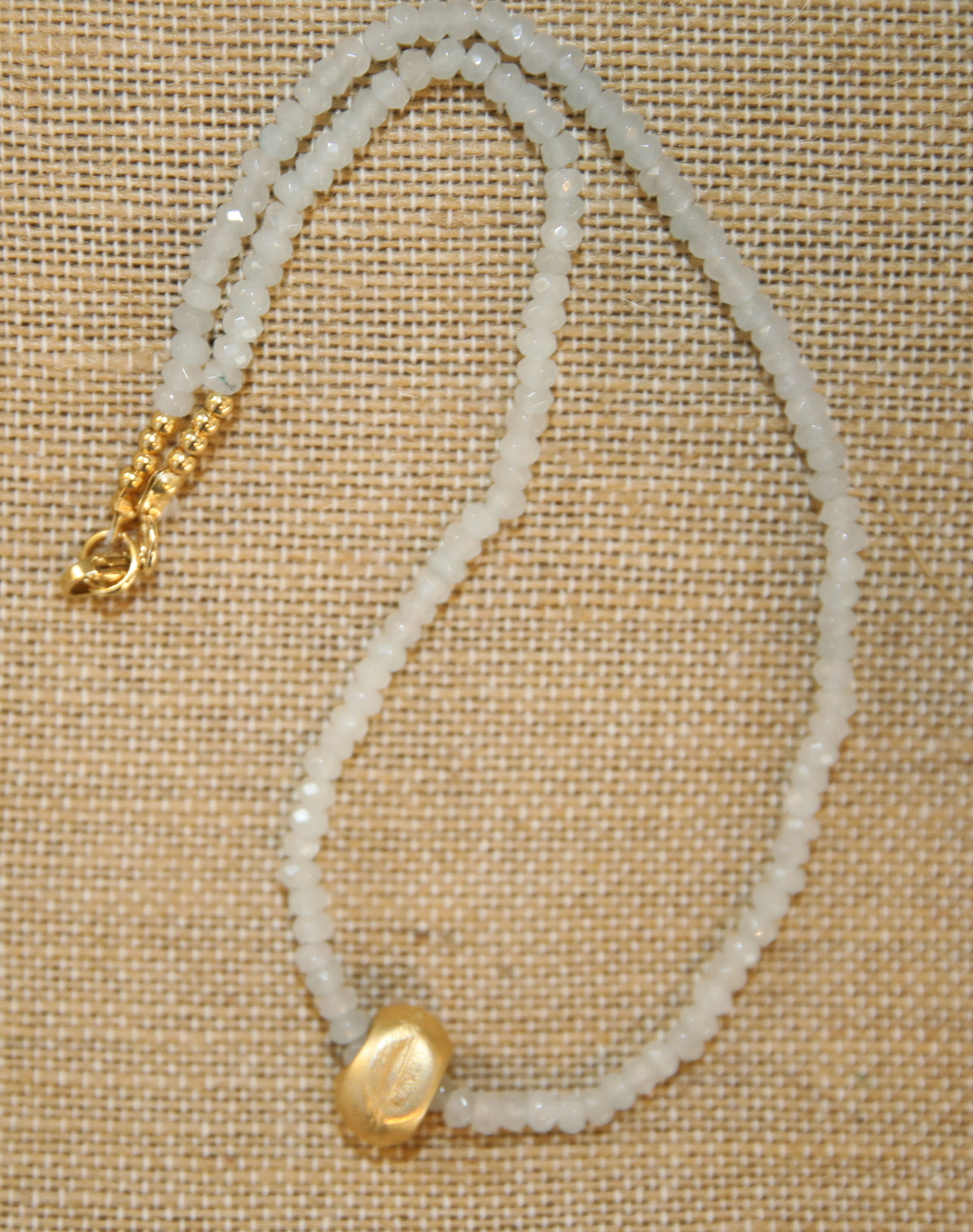 Colar Luísa de ágatas e aço dourado, branco, sobre tecido de linho