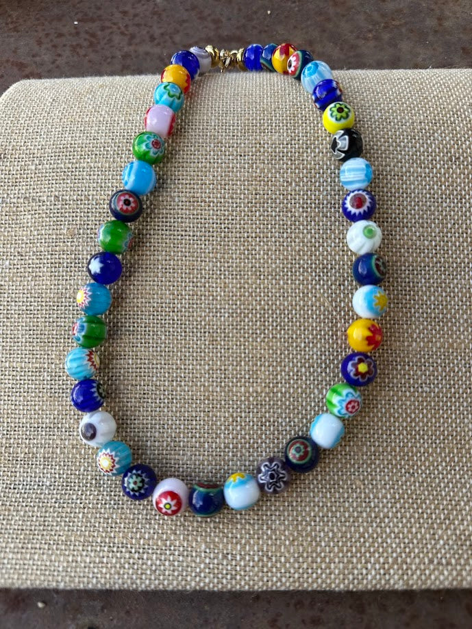 Colar Tutifruti de vidro millefiori, multicolor, sobre tecido de linho, de perto