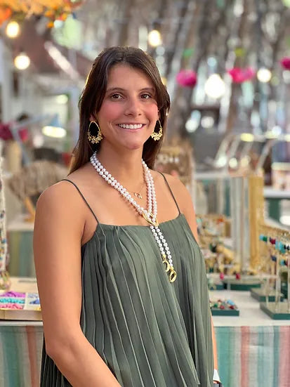 Colar Nina de pérolas com argolas douradas, usado por modelo, de lado