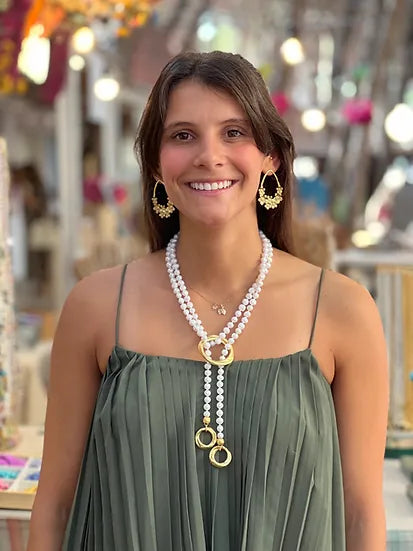 Colar Nina de pérolas com argolas douradas, usado por modelo sorridente