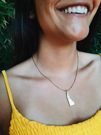 Colar Nossa Senhora de Fátima e os Pastorinhos, usado por modelo com top amarelo