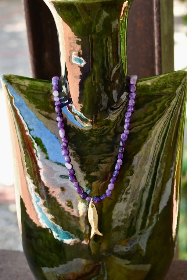 Colar de pedras com Peixinho do Mar, numa jarra de vidro verde, de perto
