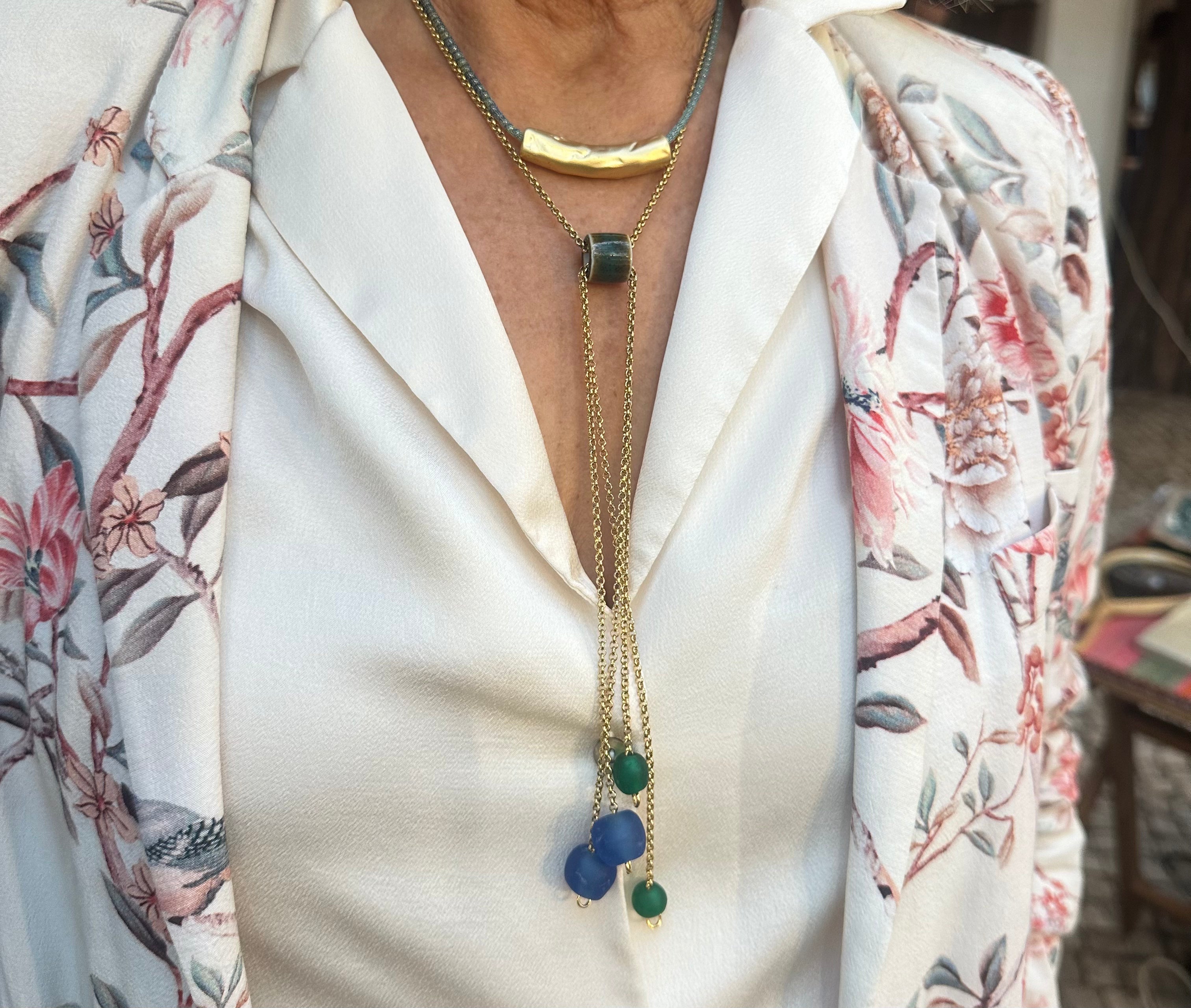 Colar Rain de aço dourado com pendentes, usado com camisa florida