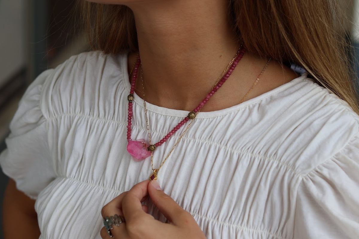 Colar Sara de aço com pendente esmaltado, usado com blusa branca