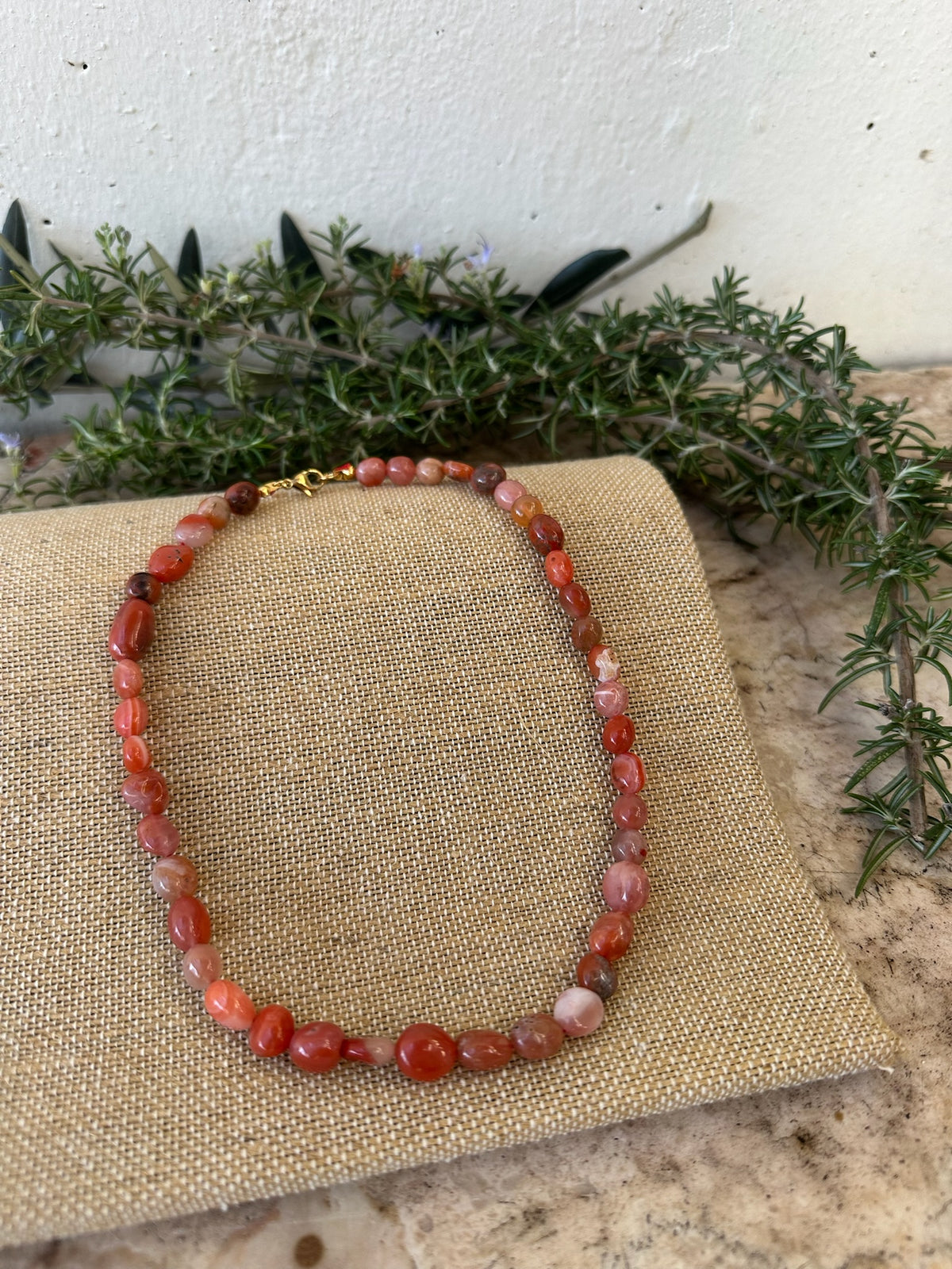 Colar Stone de amazonite, vermelho, sobre linho com ramos verdes