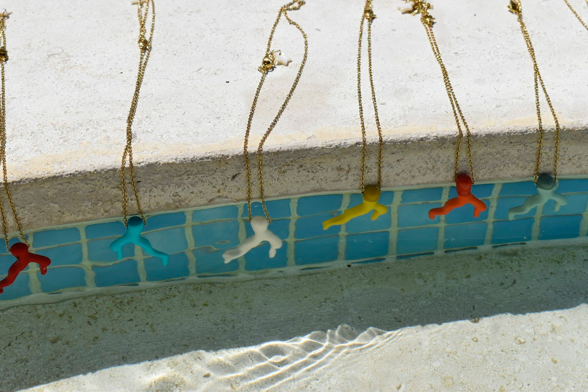 Colar Summer Reef de aço com coral de resina, vários colares sobre azulejo de piscina