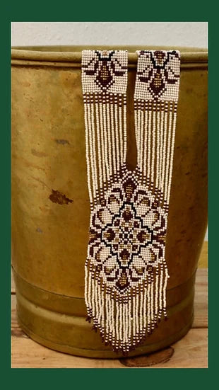 Colar Tie de missangas, num vaso dourado, vista de frente
