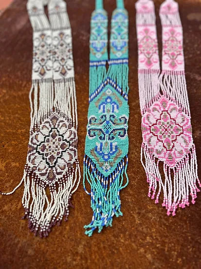 Colar Tie de missangas, três colares de missangas sobre madeira