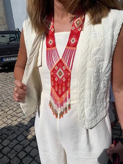 Colar Tie de missangas, vermelho, usado por modelo com colete branco