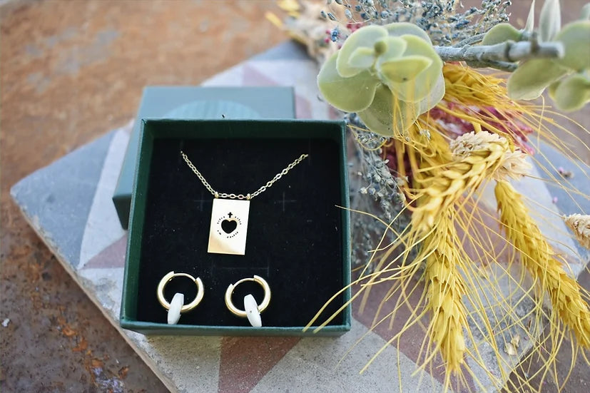 Conjunto Luna de colar e argolas de aço, caixa aberta com flores secas