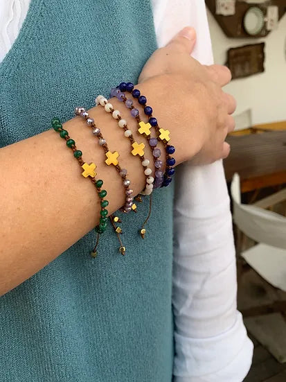 Pulseira Faith de seda com cristais, várias pulseiras no pulso, de perto